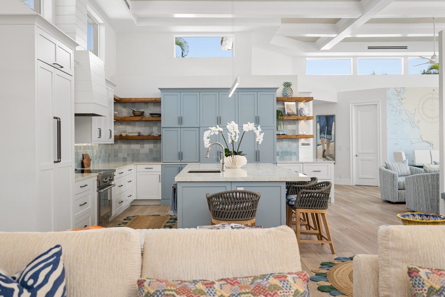 Open kitchen with blue pantry wall, white cabinets and floating wood shelves