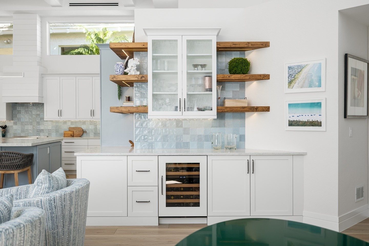 Wine bar with glass cabinet and floating shelves on blue tile