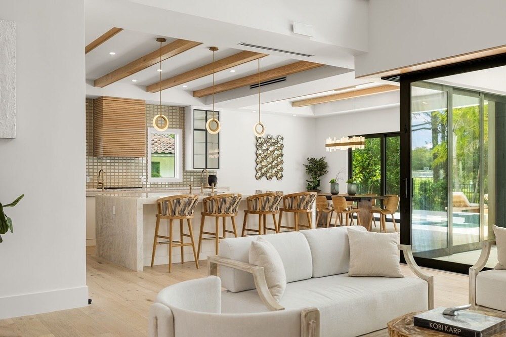 Finished open kitchen with oak beams, ring pendants and a waterfall island