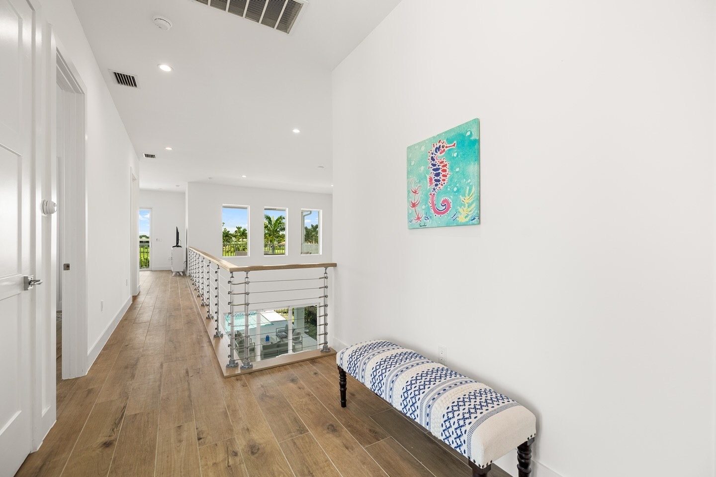 Upstairs hallway with cable railing overlooking the pool