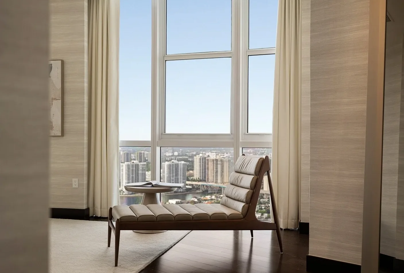 High-rise reading corner with a leather chaise and floor-to-ceiling windows