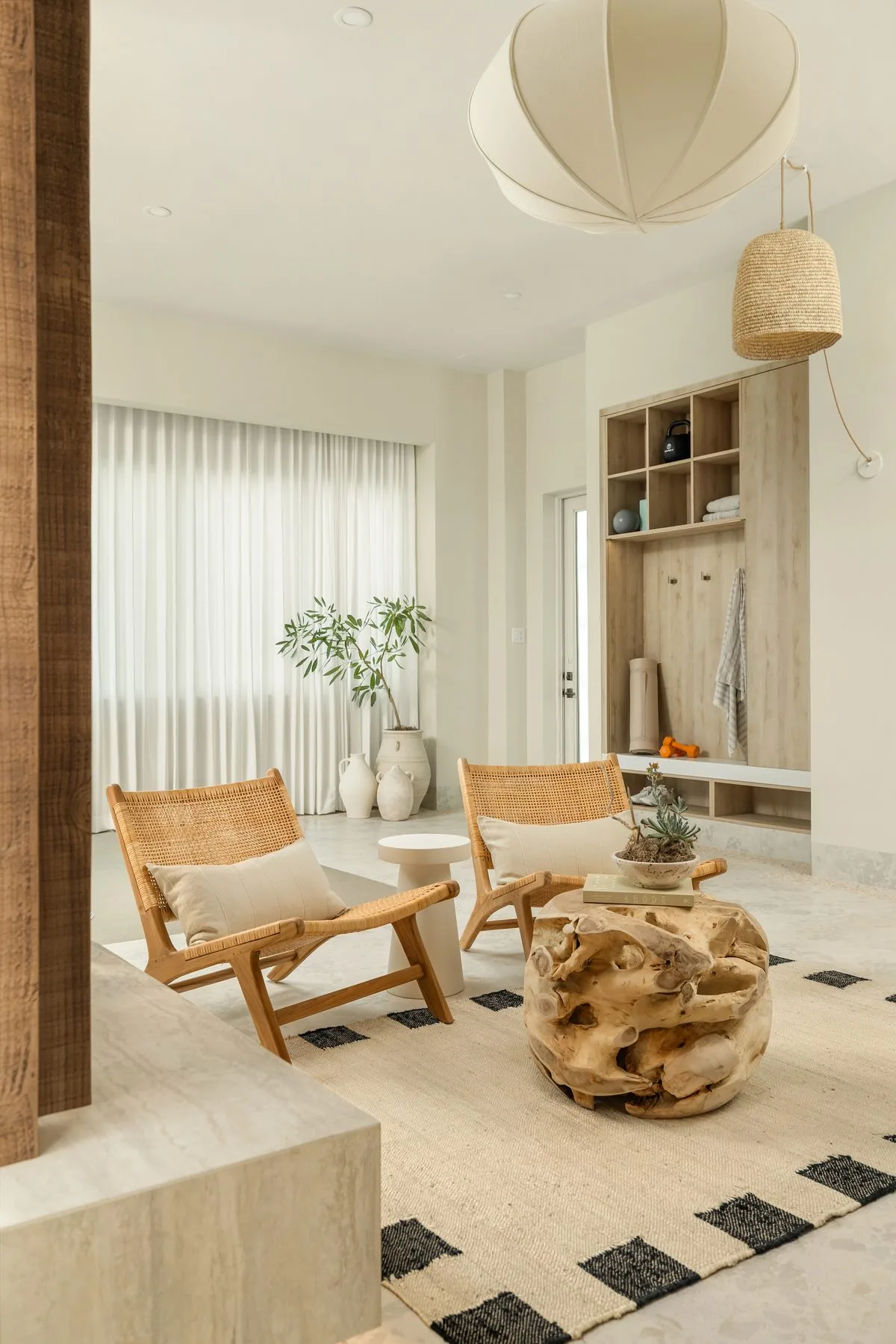 Lounge with rattan chairs, teak root table and wood slat column