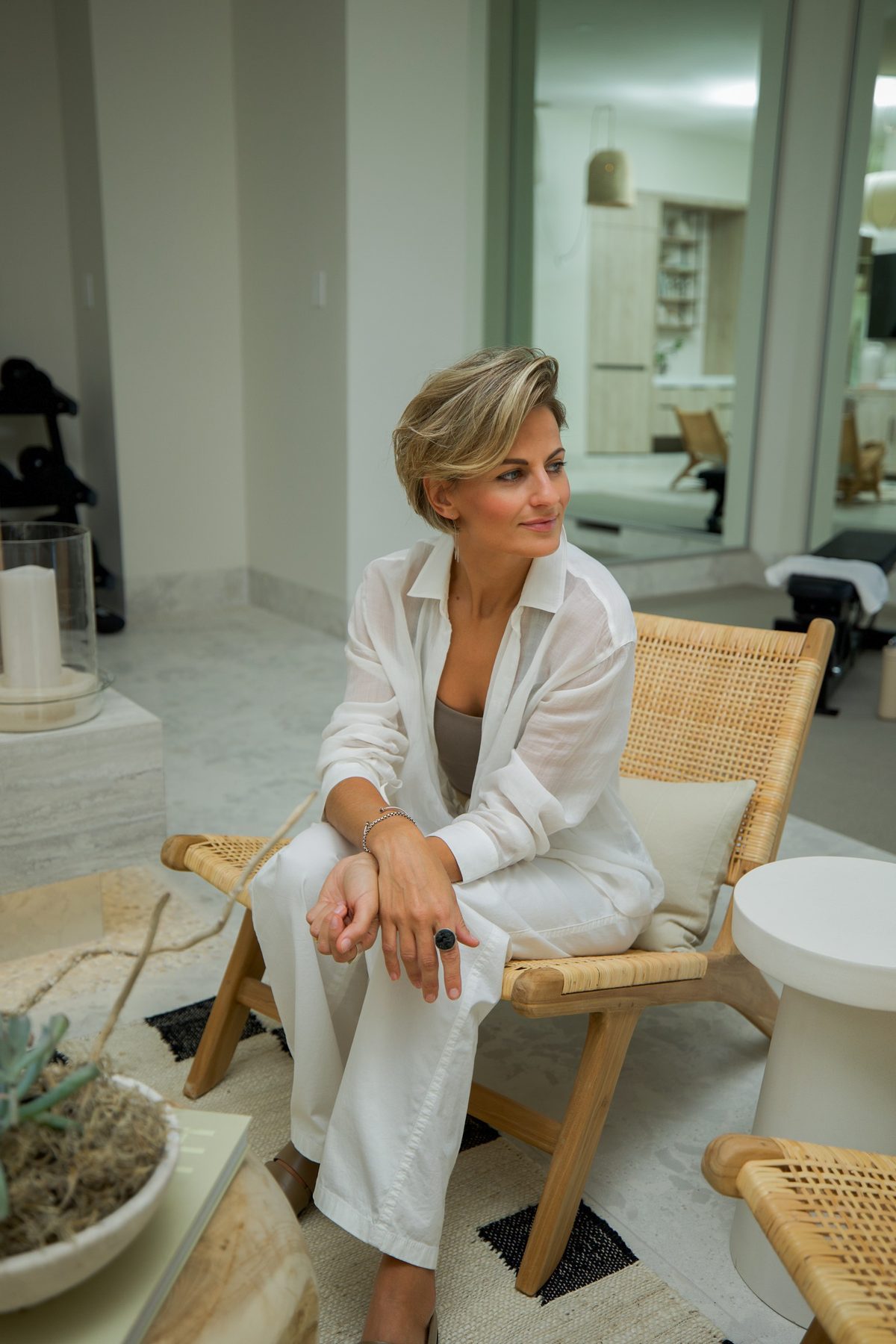 Interior designer seated in a rattan chair in her finished project