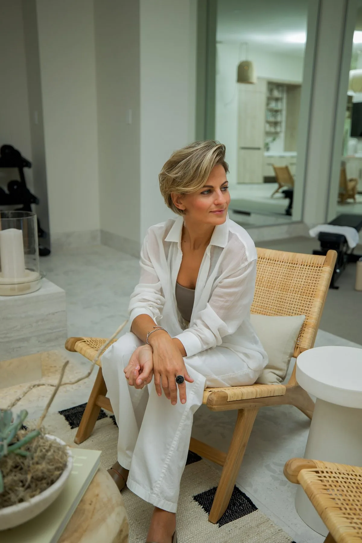 Interior designer seated in a rattan chair in her finished project