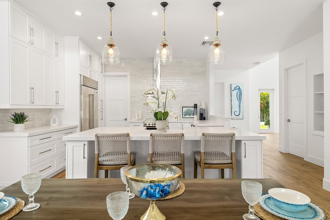 White coastal kitchen with island and pendant lights