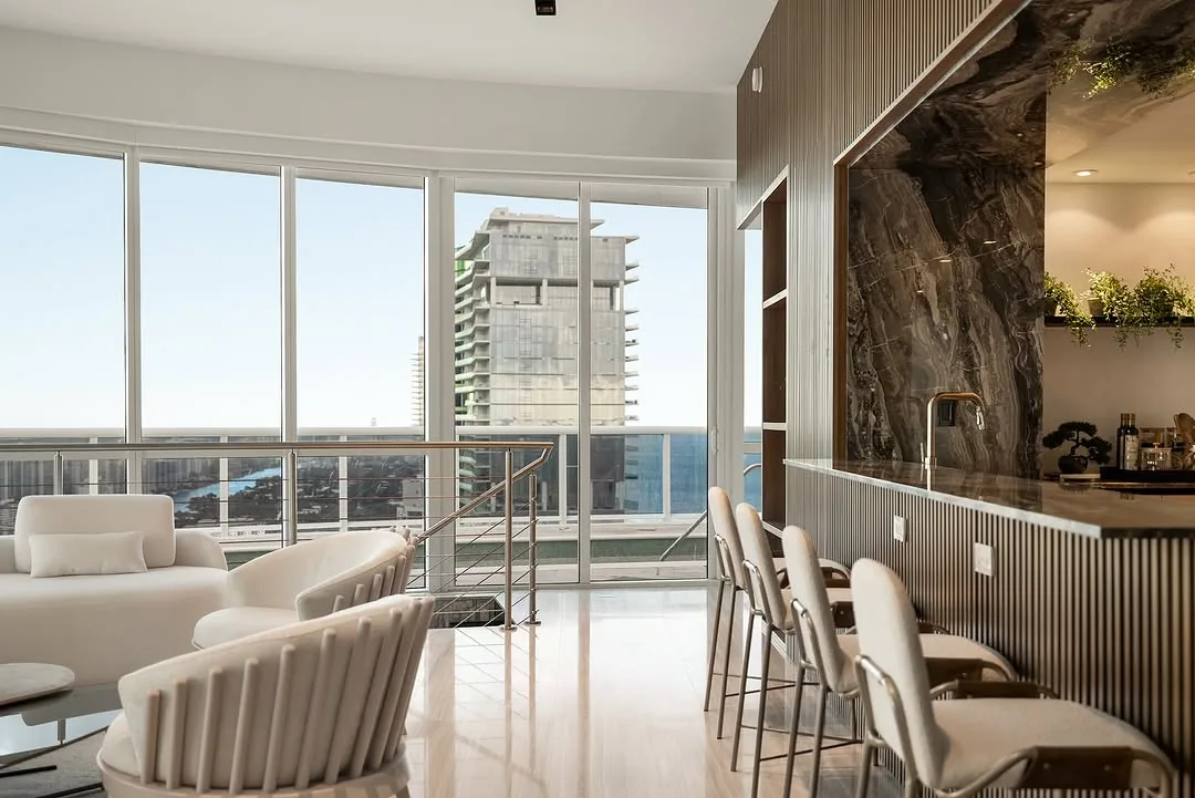 High-rise condo living room and bar with floor-to-ceiling water views
